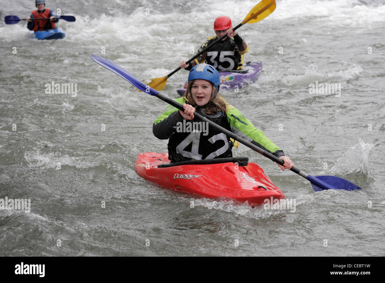 girl female canoeist taking part in inter university competition on River Exe Exeter 4/2/12 shooting over a weir Stock Photo