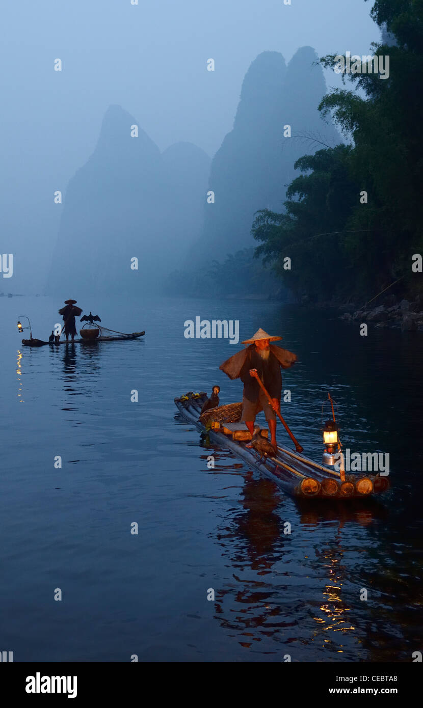 Two early morning Cormorant fishermen on bamboo rafts on Li or Lijiang river near Xingpingzhen Yangshuo, Guilin, Guangxi China Stock Photo