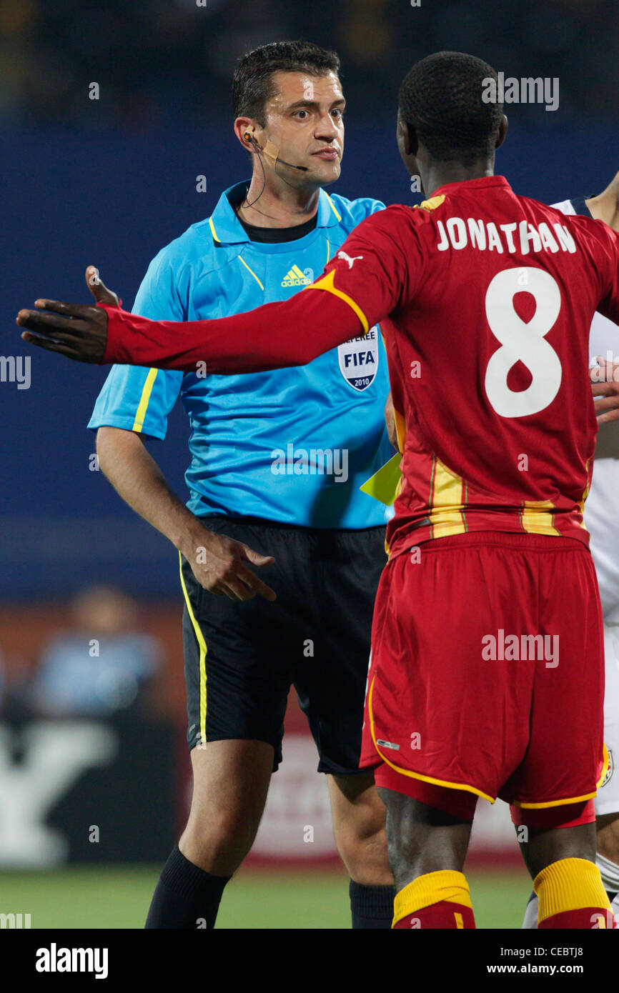 Jonathan Mensah of Ghana protests to referee Viktor Kassai after he was booked during a 2010 FIFA World Cup round of 16 match. Stock Photo