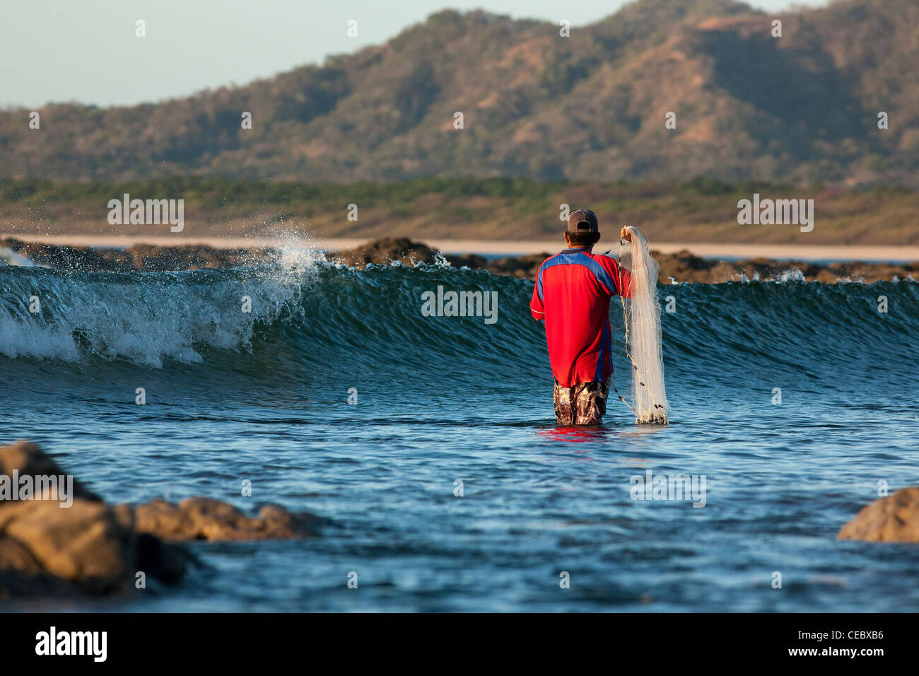 A fisherman gets ready to cast his net, on the beach in Tamarindo ...