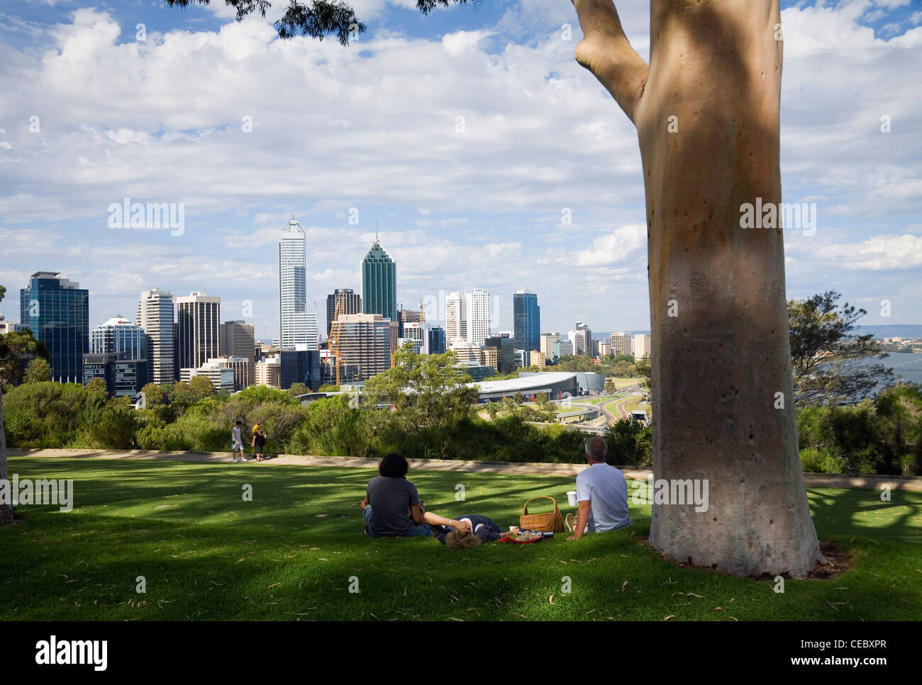 Couple having picnic under the shade of a tree in Kings Park, overlooking Perth city. Perth, Western Australia, AUSTRALIA Stock Photo