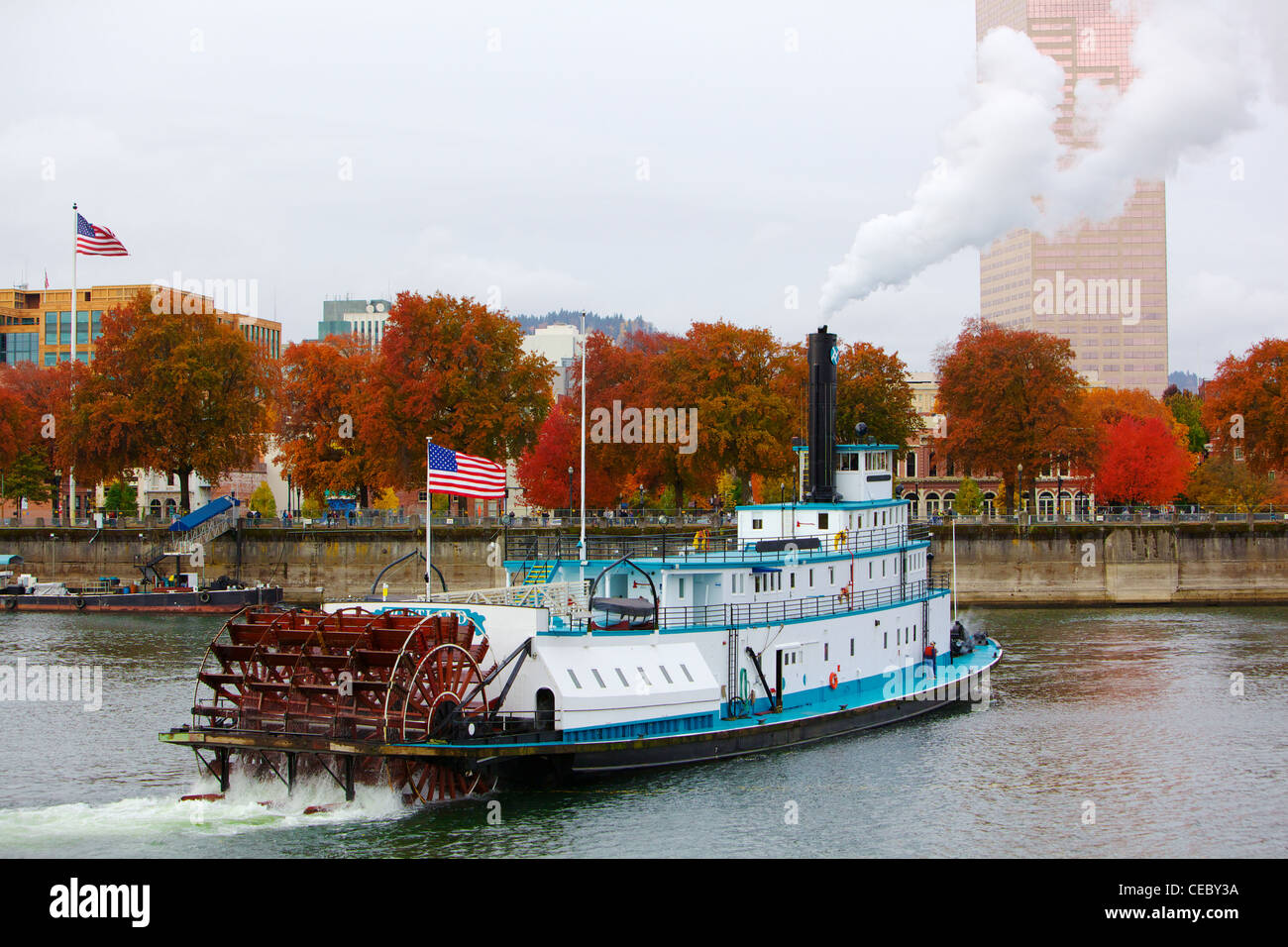 Ferry or steam boat in Portland on Williamette river under steam with two American flags on an overcast day Stock Photo