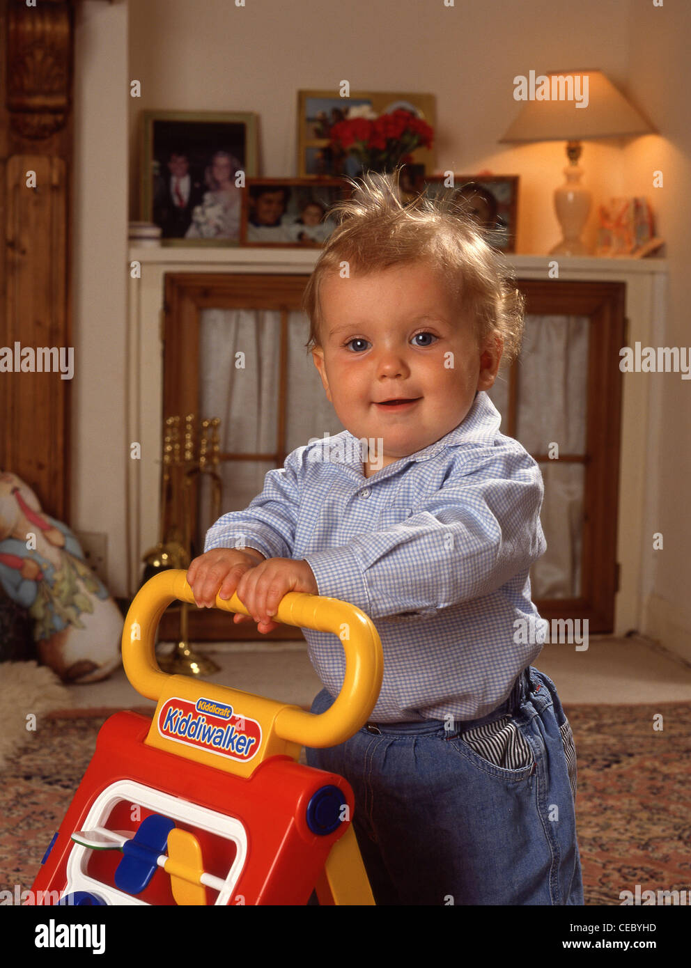 Young boy learning to walk with walker, Berkshire, England, United
