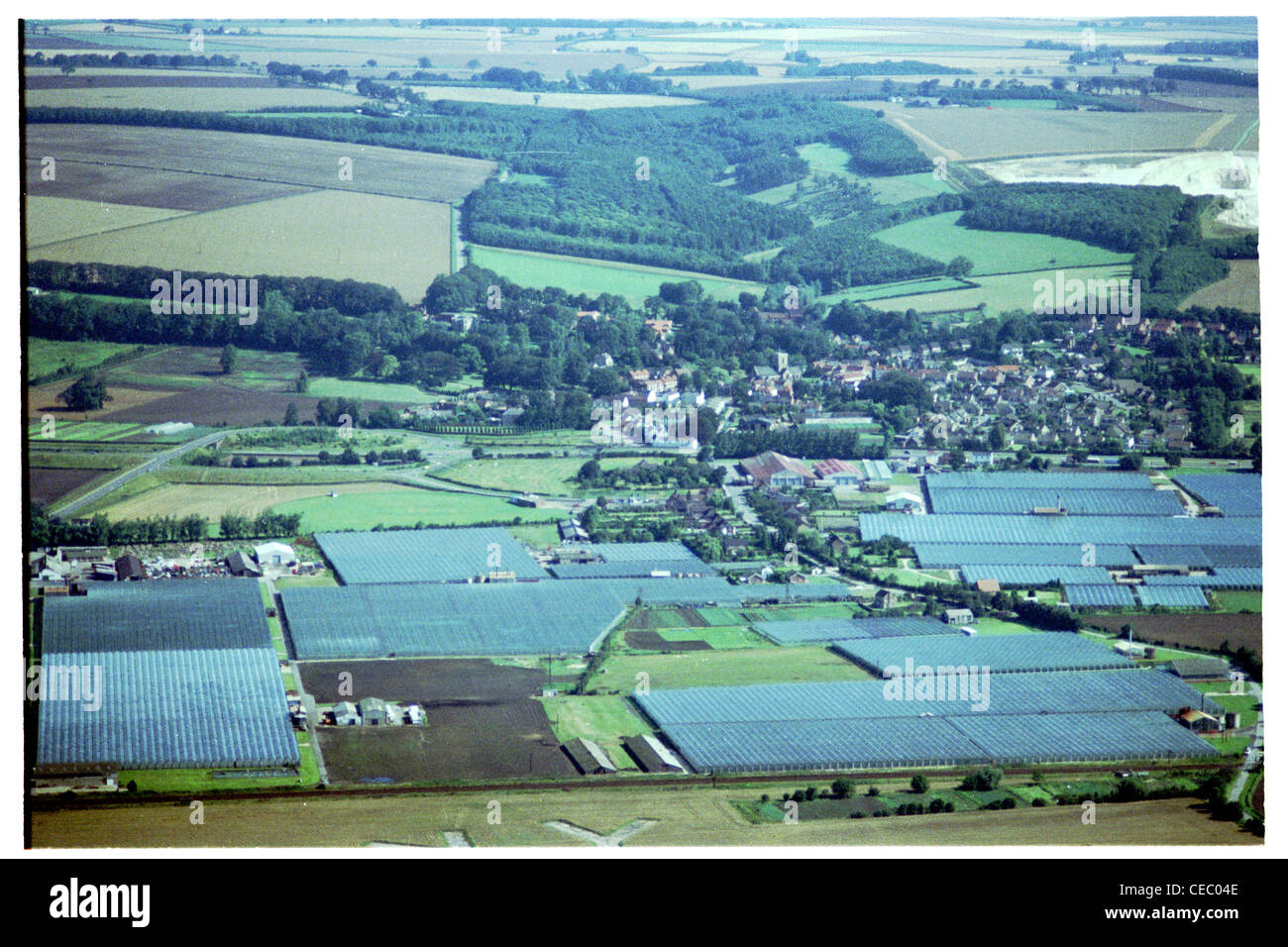 Oblique aerial photograph looking north from around 1500ft of village of Welton, showing glasshouses in the foreground Stock Photo