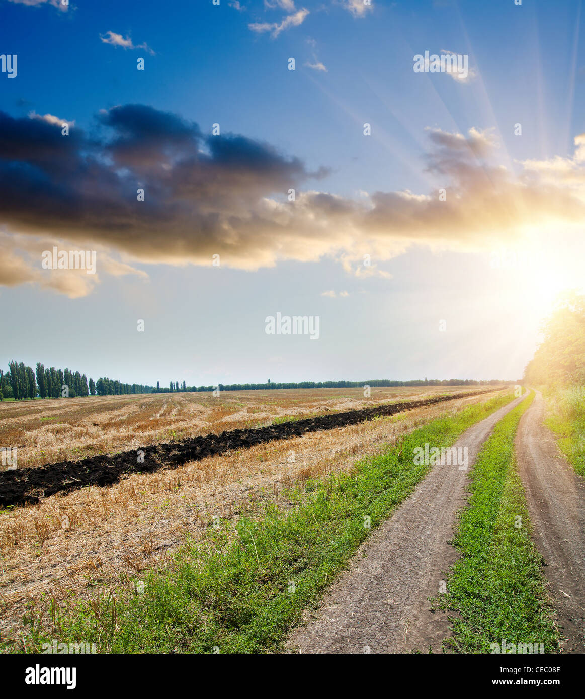 sunset over field and rural road with dramatic sky Stock Photo - Alamy