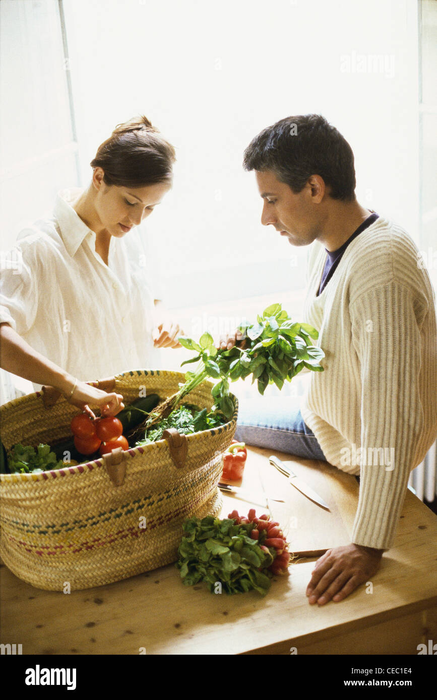 Couple emptying basket of fresh produce Stock Photo