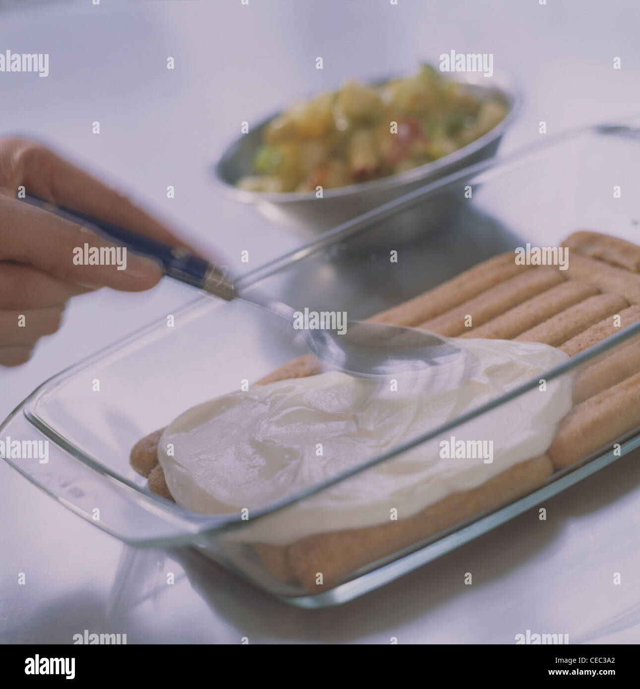 Adding curd cream onto the sponge fingers Stock Photo Alamy