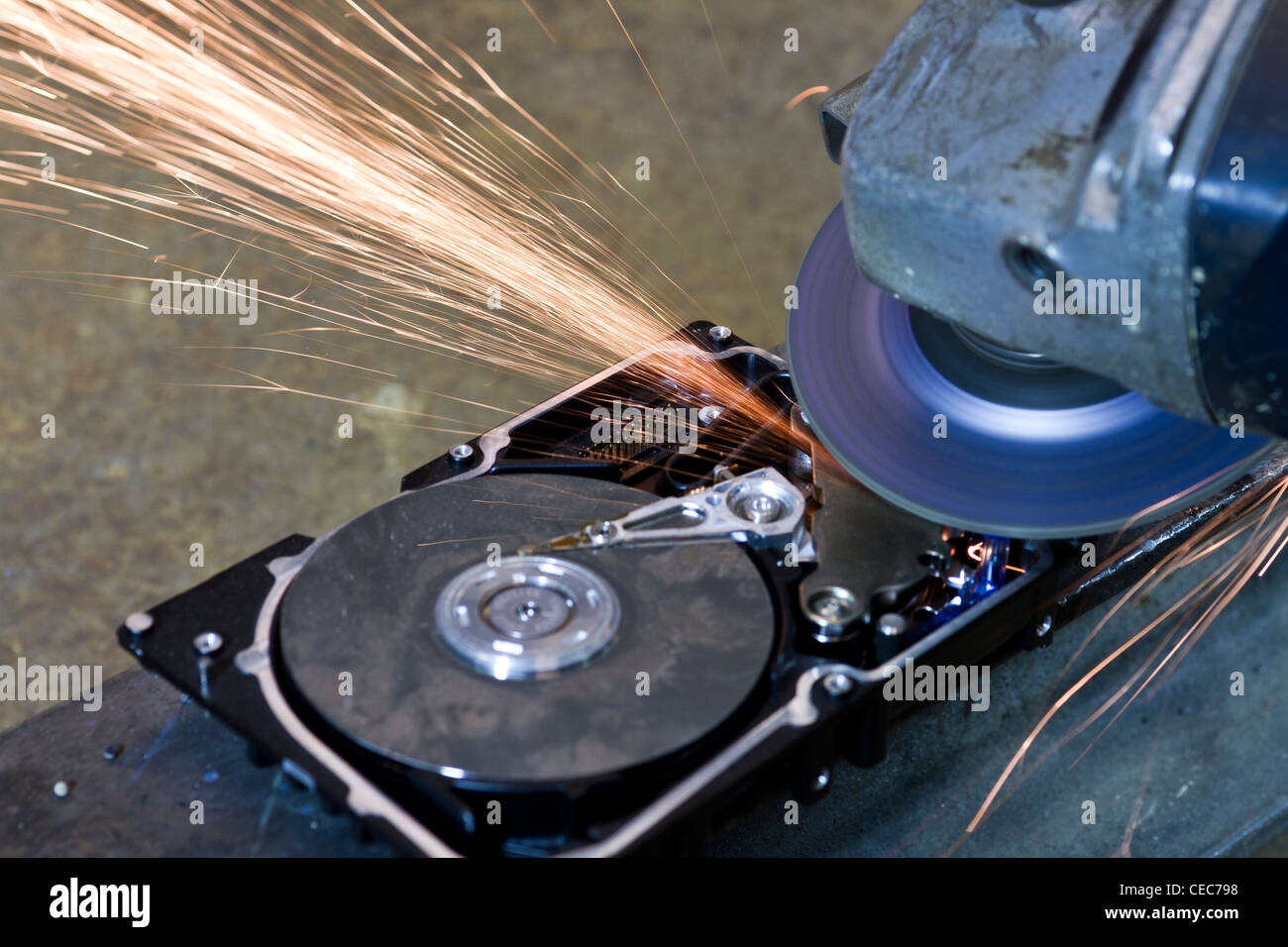 hard disk drive with rotating grinder and sparks in front of rusty back Stock Photo