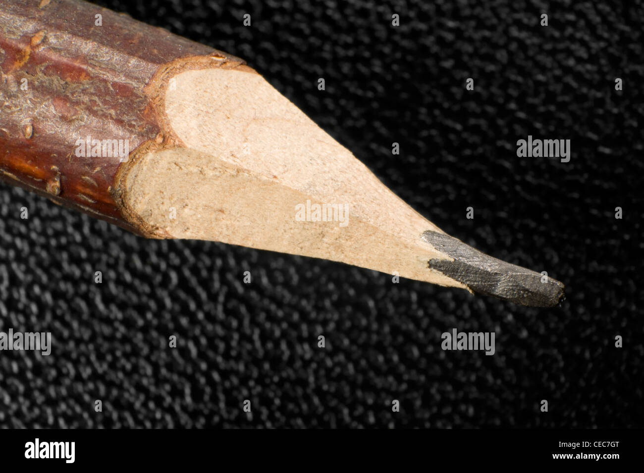 detail of a rural wooden pencil tip in front of a black leather surface Stock Photo