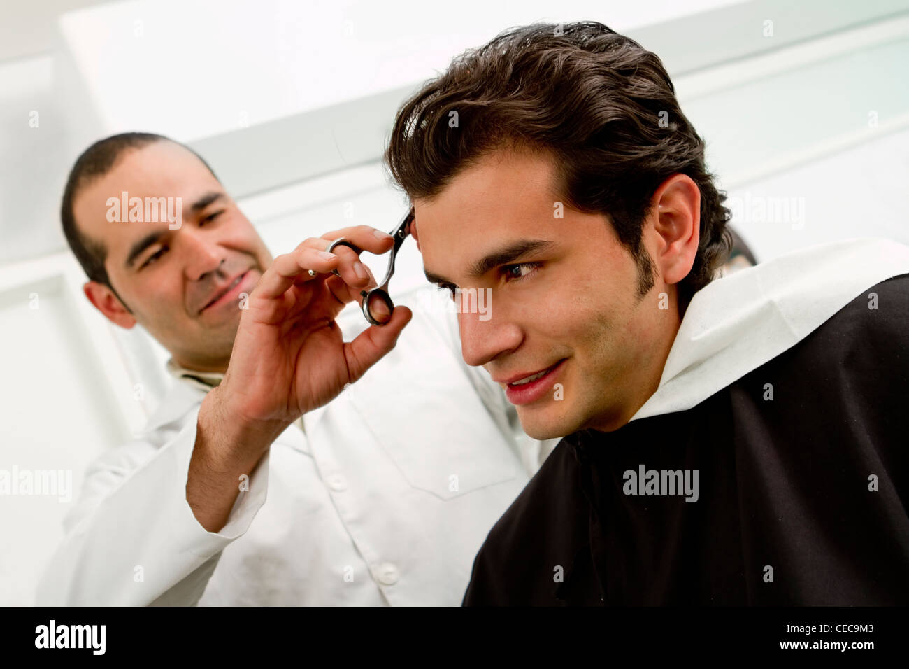 Hispanic man having hair cut in barber shop Stock Photo