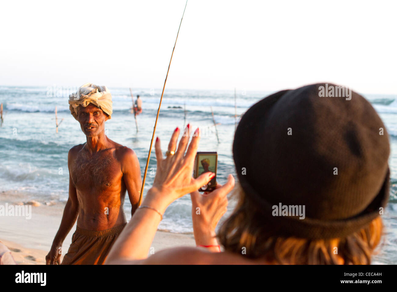 Tourist making pictures of stilt fisherman Weligama Sri Lanka Asia Stock Photo