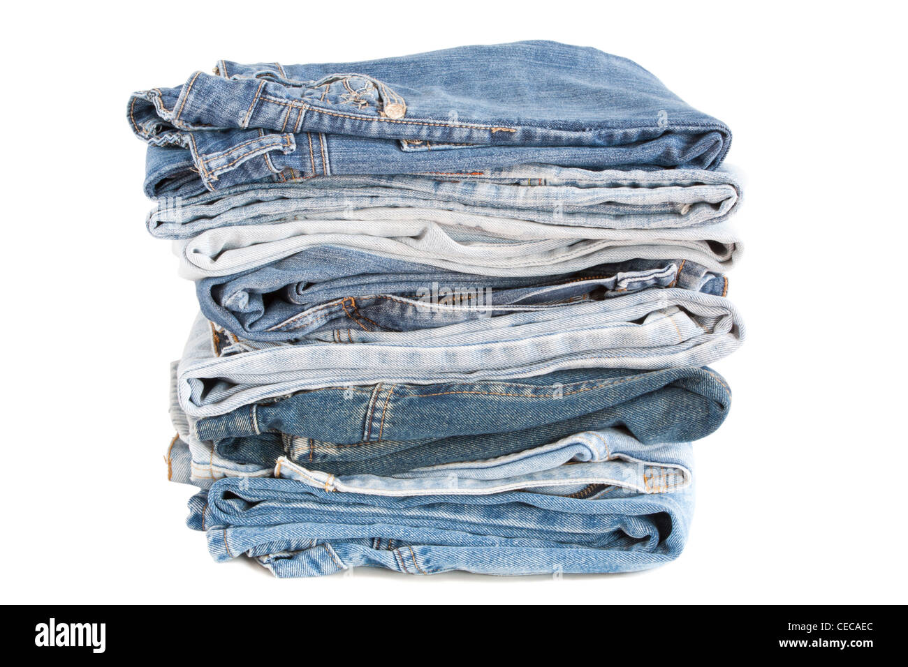 Some pairs of blue jeans stacked over a white background. Stock Photo