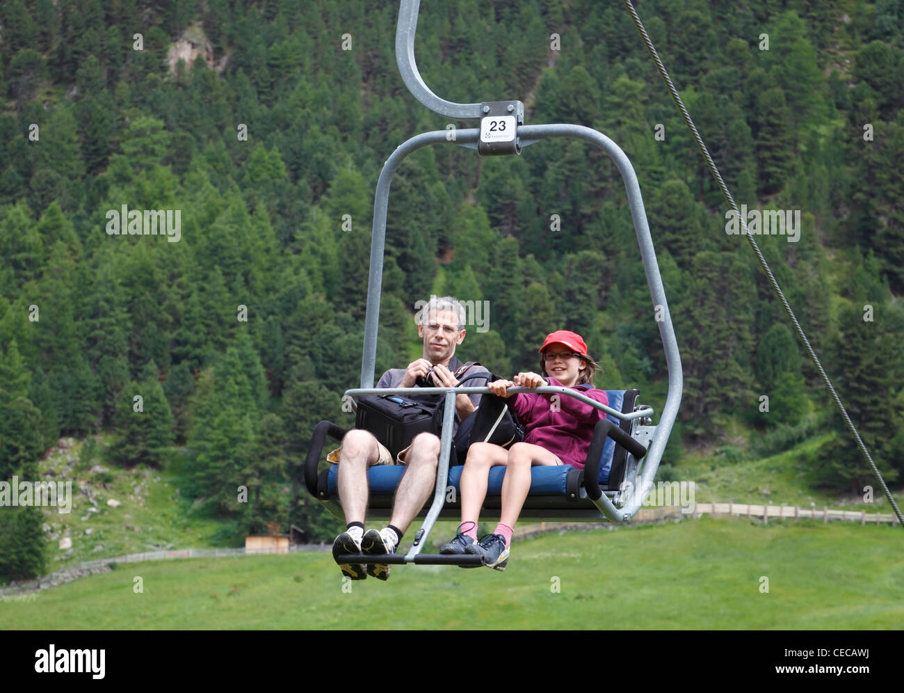 Father and daughter in chair lift to summer mountain trekking from alpine village Vent, Ötztal, Austria Stock Photo