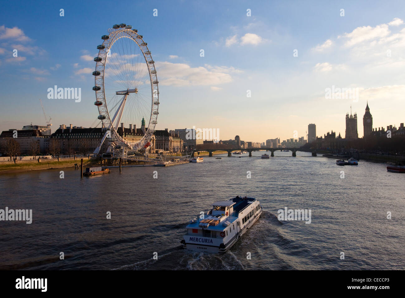 View over the London Eye and Westminster as a passenger boat cruises down the River Thames, Central London, England, UK. Stock Photo