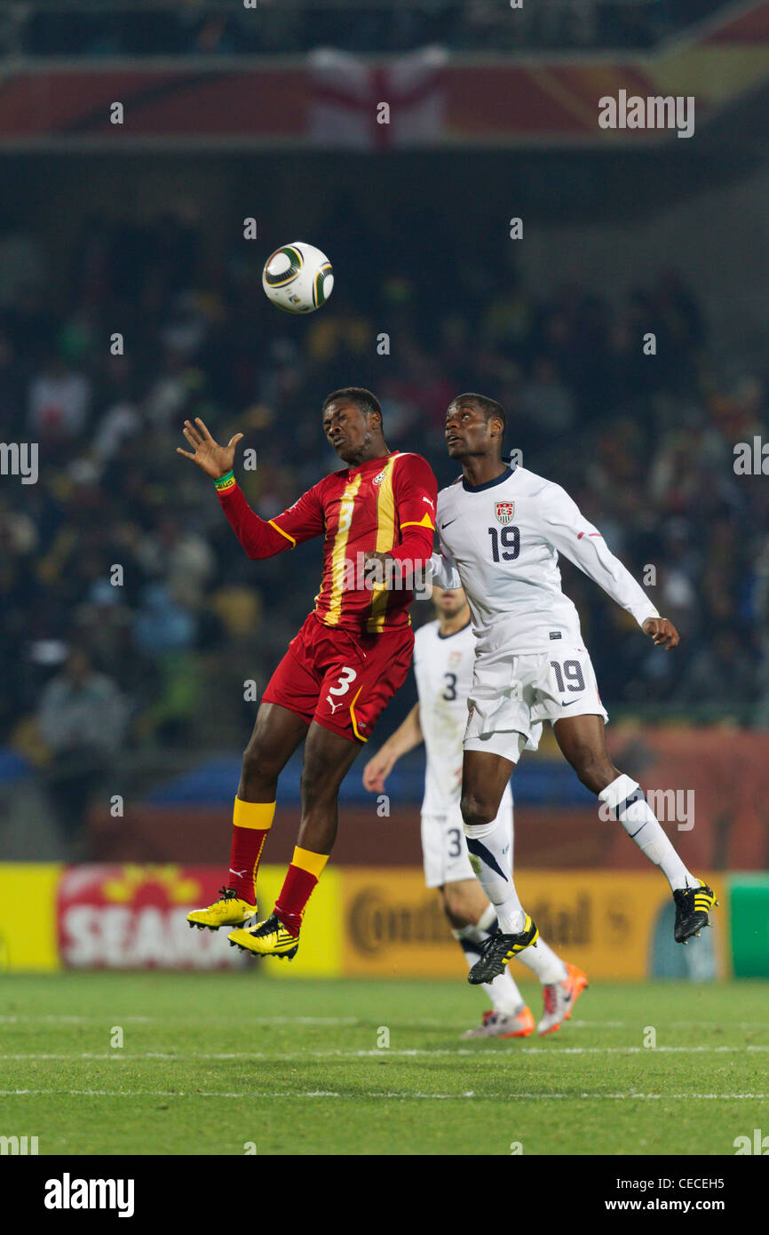 Asamoah Gyan of Ghana (L) and Maurice Edu of the USA (R) jump for the ball during a 2010 FIFA World Cup round of 16 match. Stock Photo