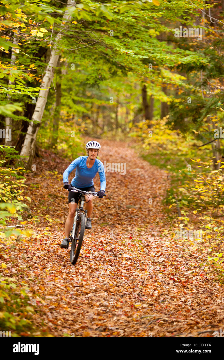 A woman mountain biking on a trail on Millstone Hill in Barre, Vermont