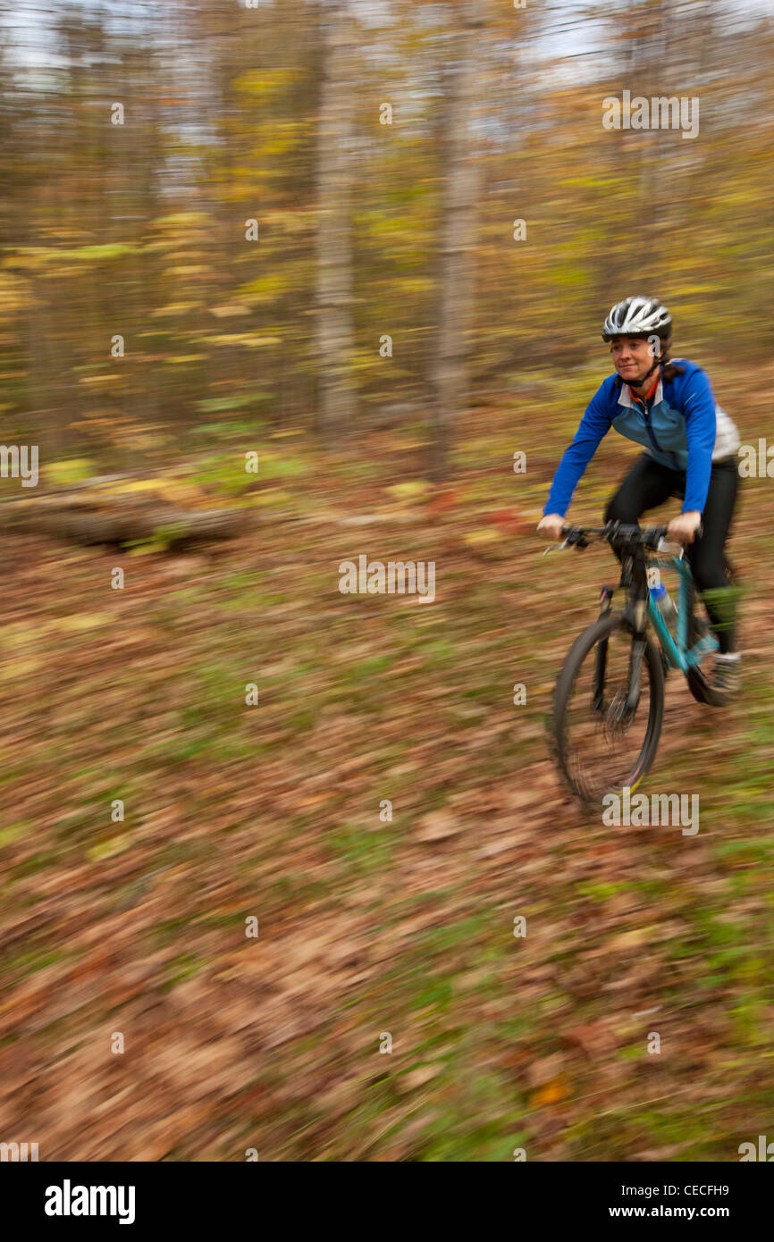 A woman mountain biking on a trail on Millstone Hill in Barre, Vermont