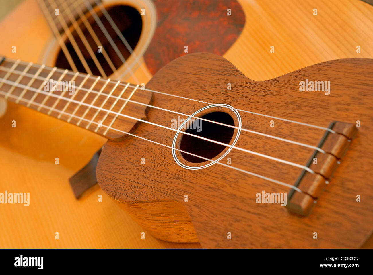 Martin ukulele posed on top of a Martin dreadnought acoustic guitar. Stock Photo