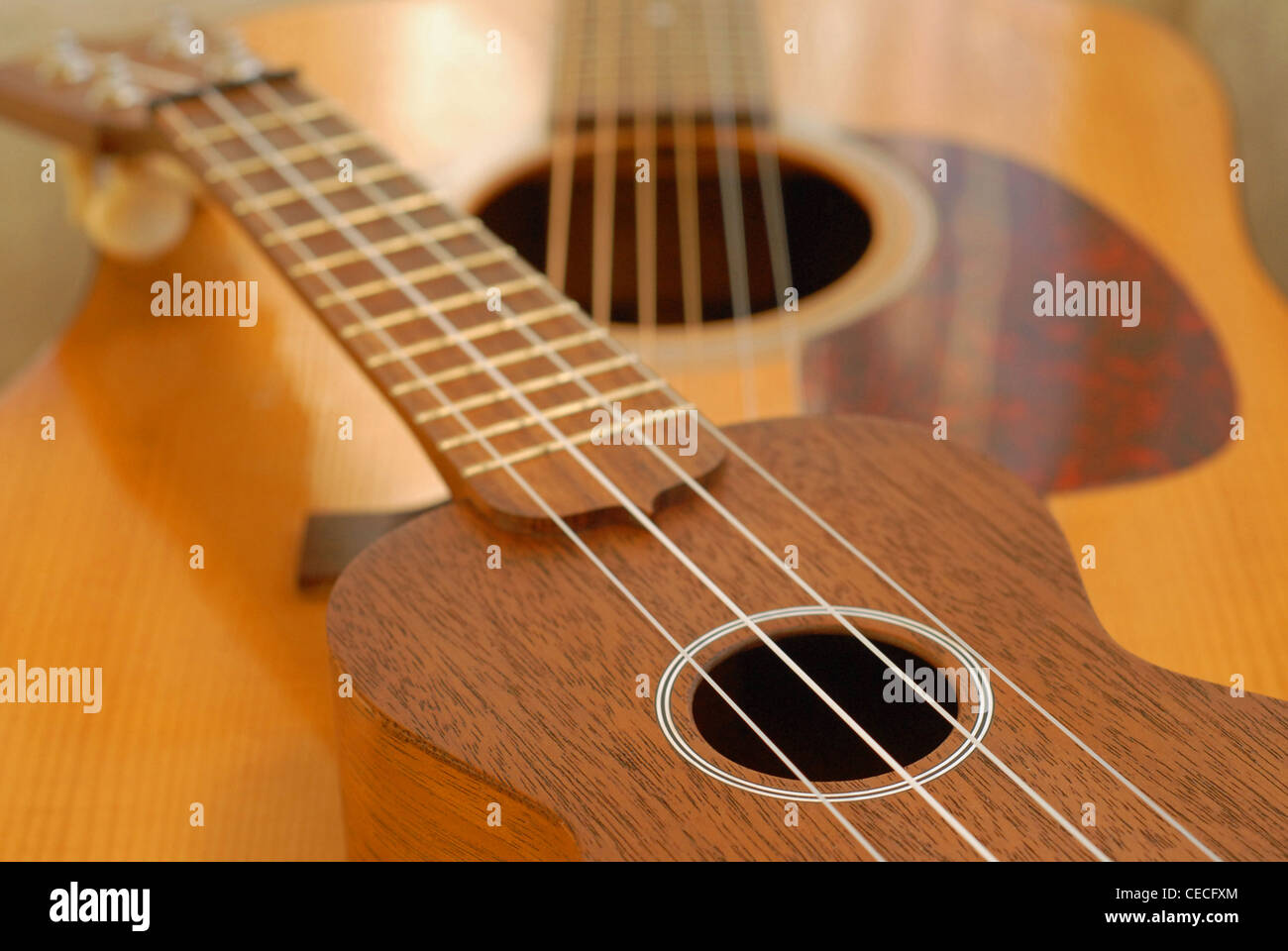 Martin ukulele posed on top of a Martin dreadnought acoustic guitar. Stock Photo