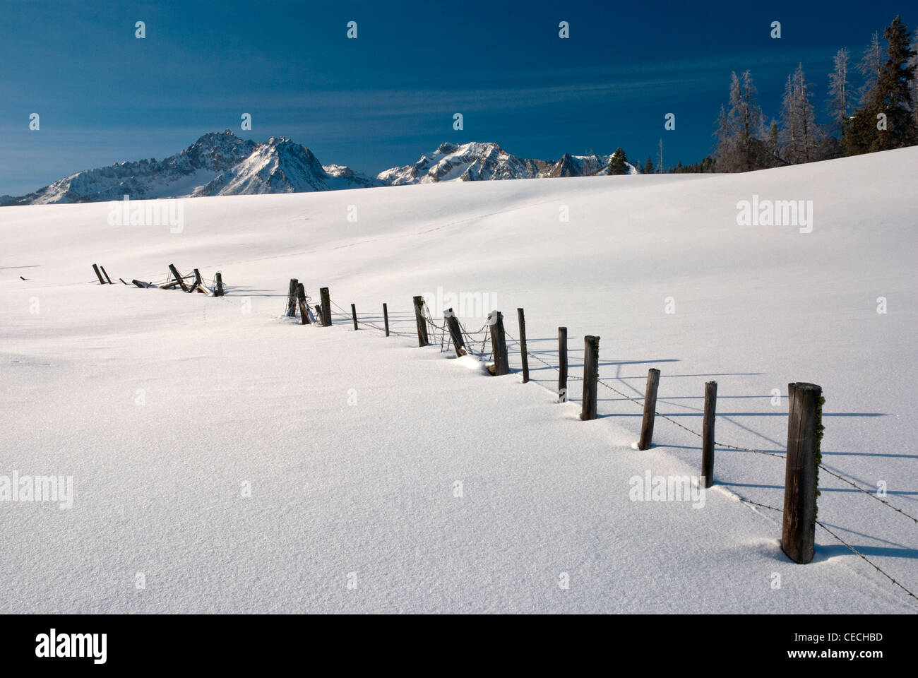 Barbed Wire fence covered with snow in an Idaho mountain scene Stock Photo