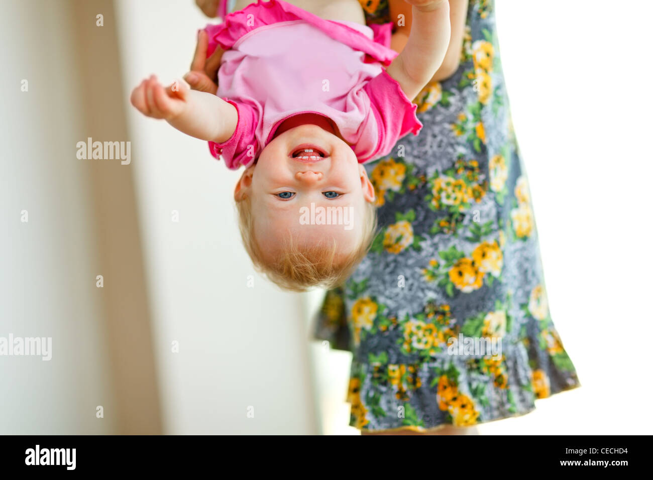 Mother holding smiling baby upside down Stock Photo