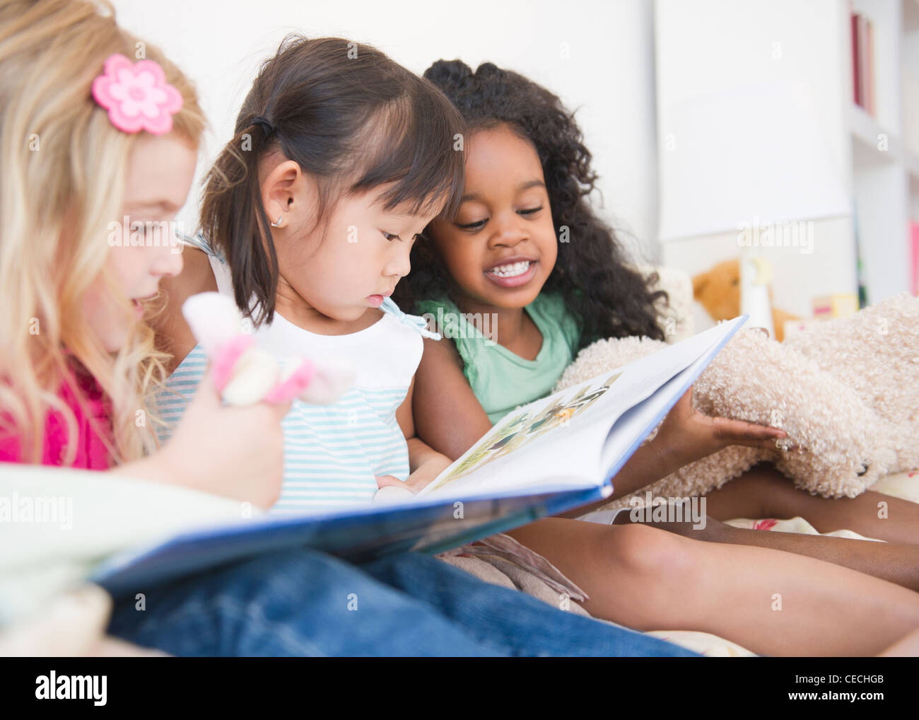 Girls reading book together Stock Photo