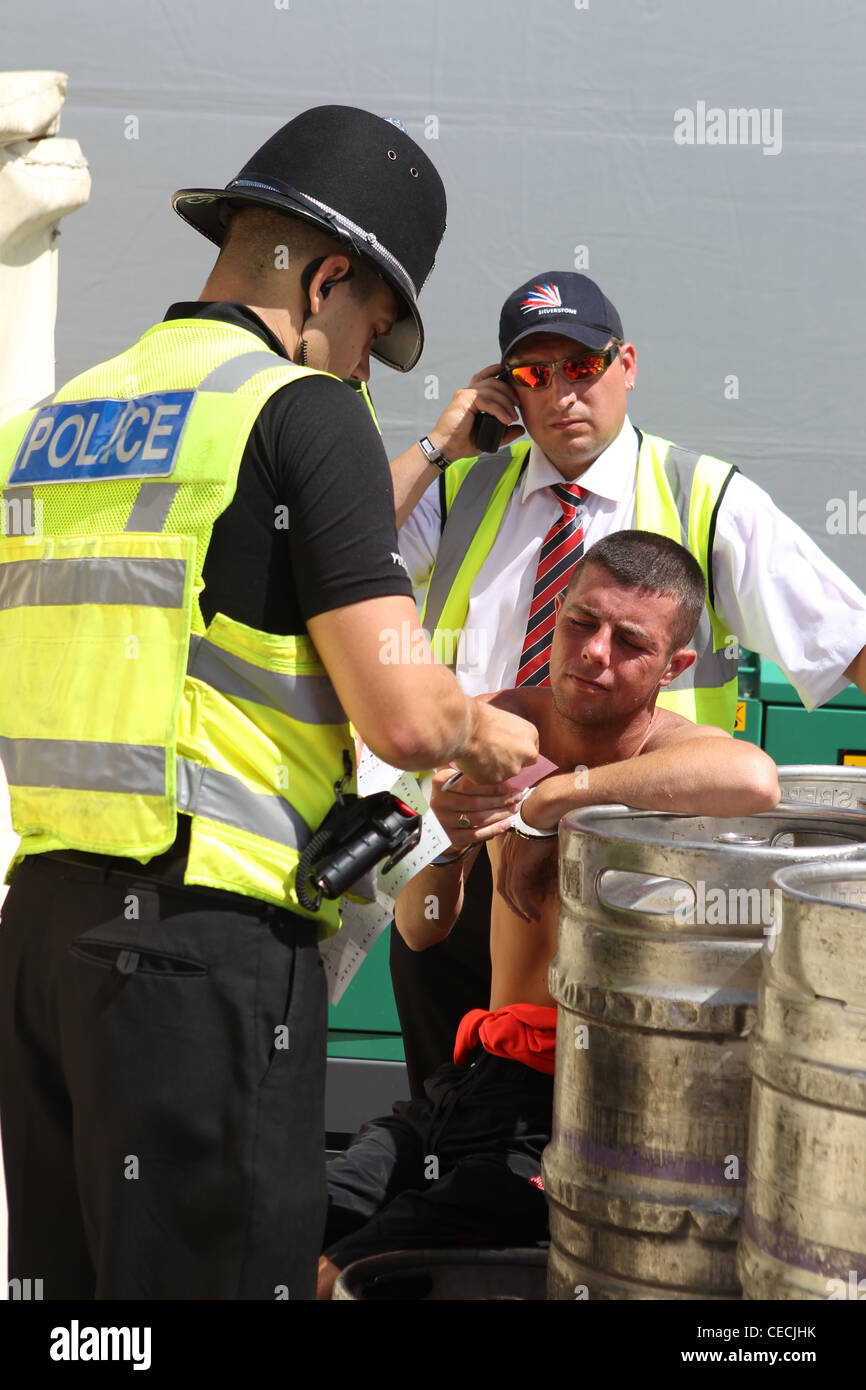 Police questioning and arresting man at the British Formula One Grand Prix Stock Photo