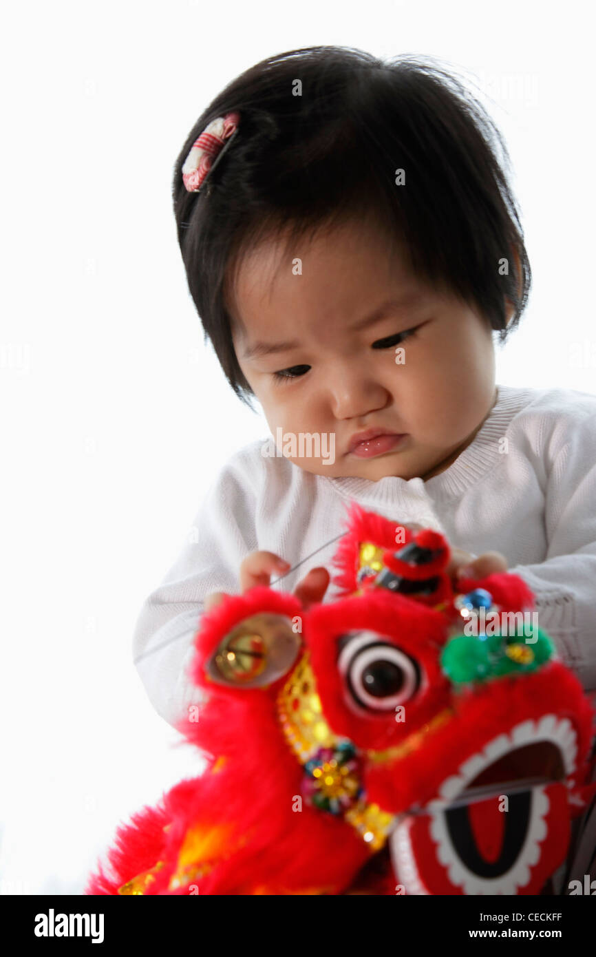 Baby holding red Chinese dragon toy Stock Photo