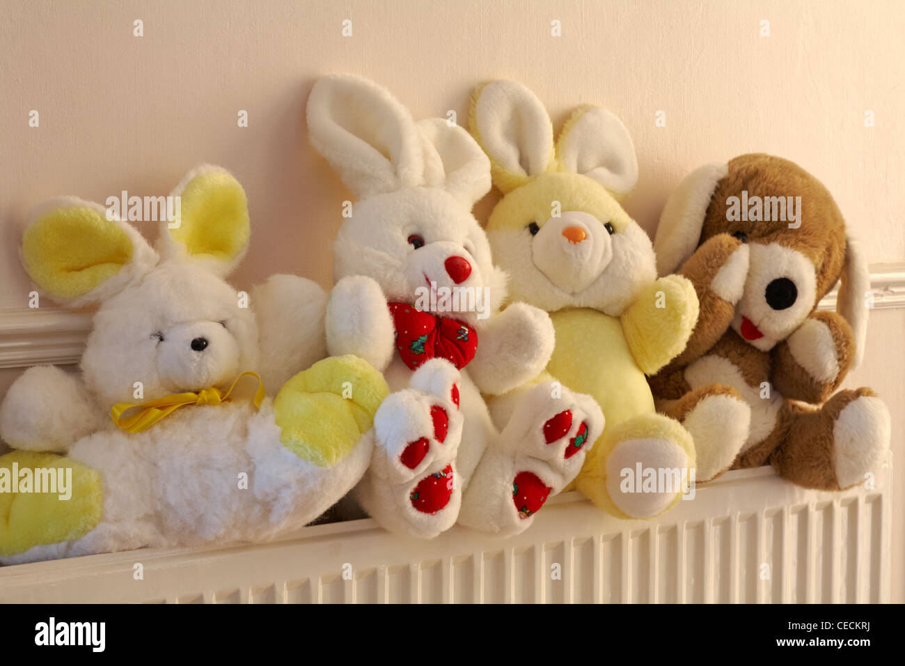 soft cuddly toys sat on radiator Stock Photo