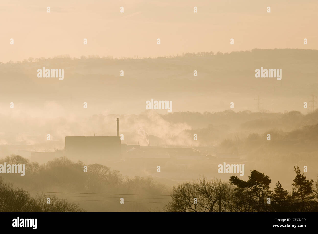 High view over Esholt waste water treatment (sewage) works nestling in wooded valley, on cold grey misty winter morning - West Yorkshire, England, UK. Stock Photo