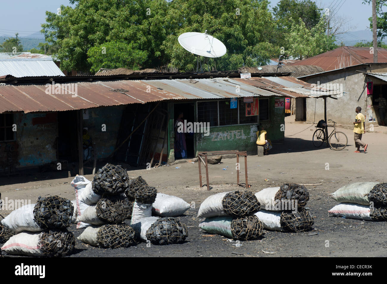 Satellite dish and bags of charcoal in a village near Mombo Kilimanjaro Region Tanzania Stock Photo