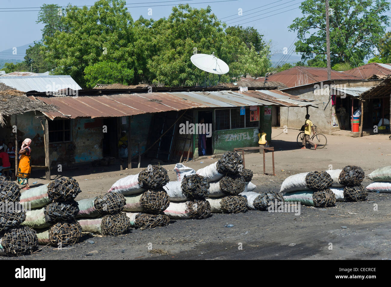 Satellite dish and bags of charcoal in a village near Mombo Kilimanjaro Region Tanzania Stock Photo