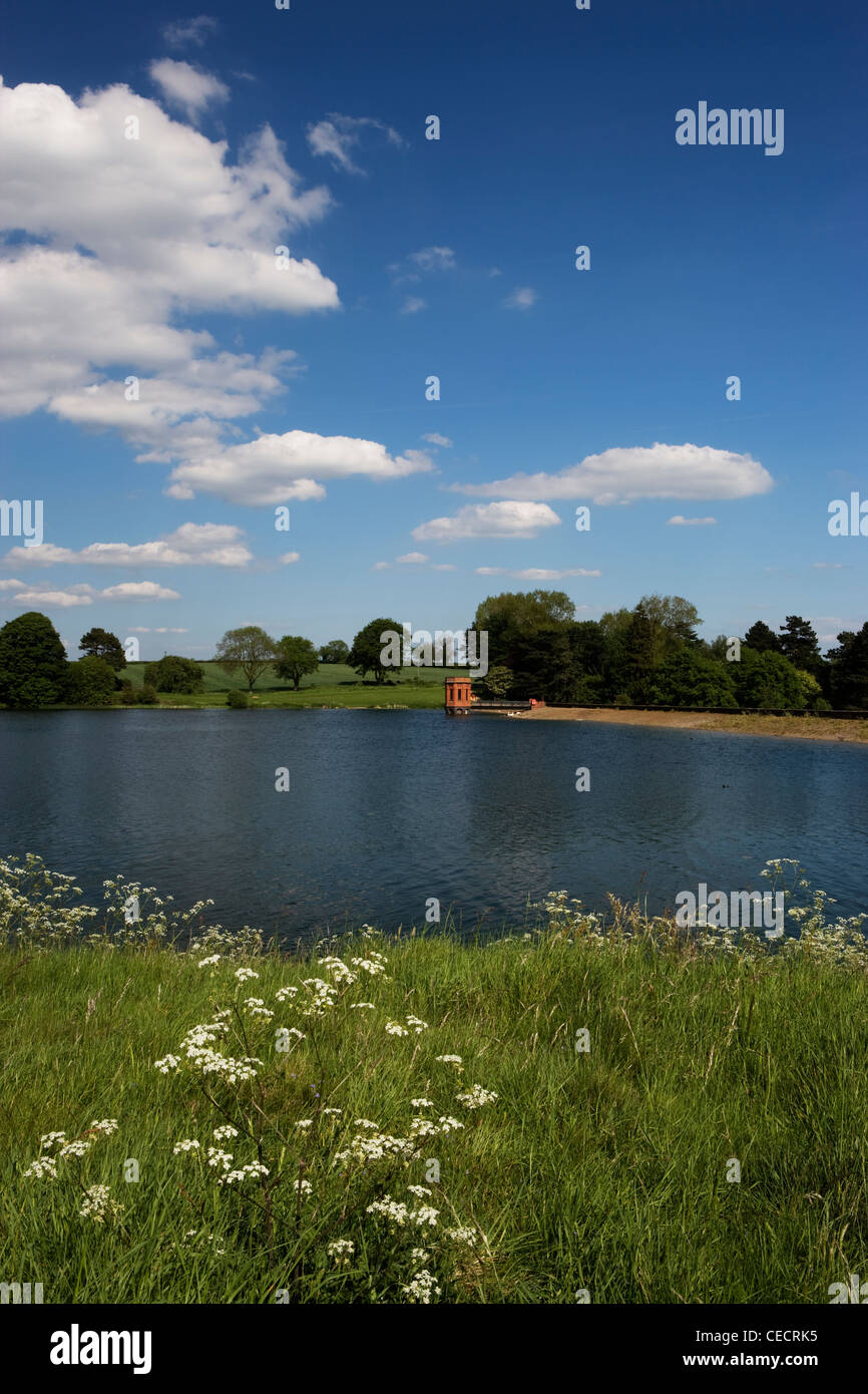 View over the grassy bank across the reservoir towards the water tower at sywell country park. Stock Photo