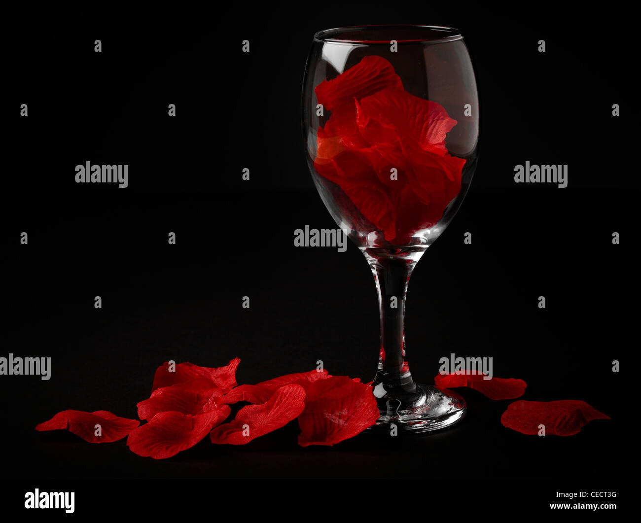 Silk rose petals in a wine glass Stock Photo