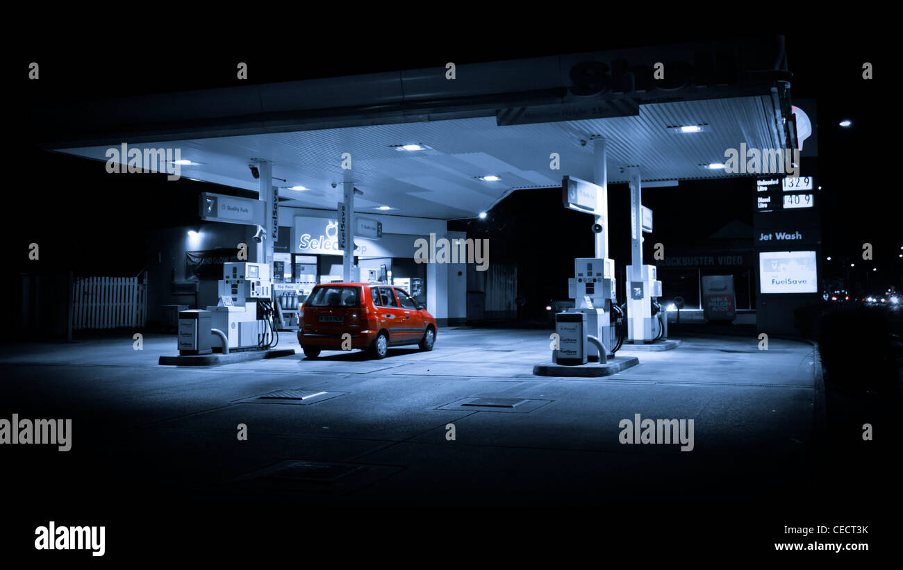 Shell filling station at night with a red car Stock Photo