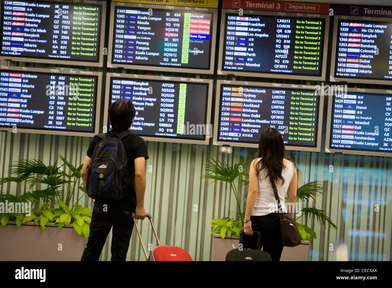 Passengers look at flight departure and arrival information on