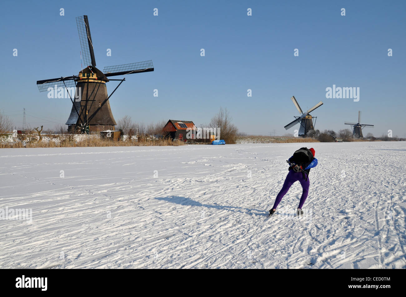 Windmills and ice skater at Kinderdijk, Netherlands, Europe Stock Photo