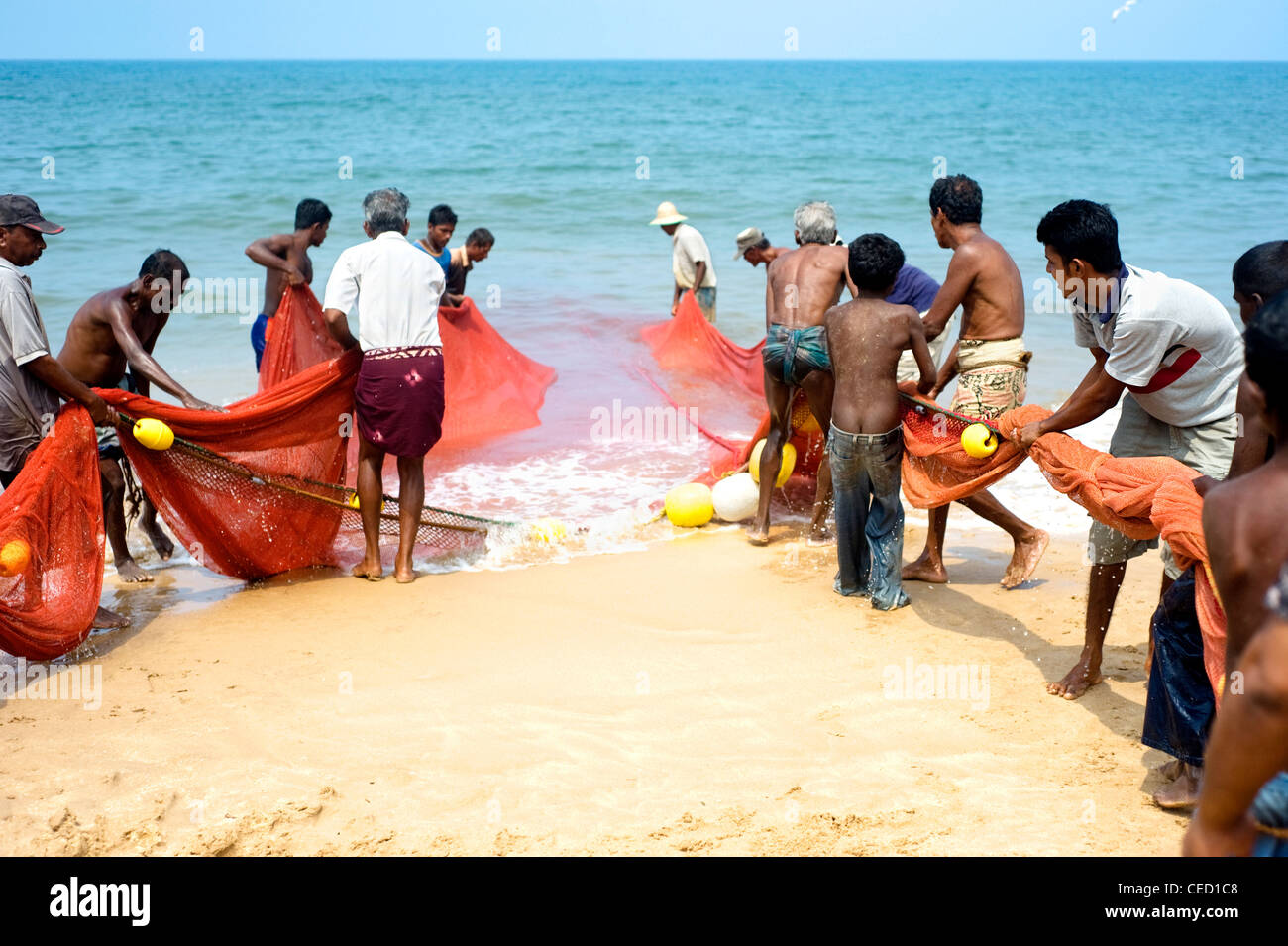 Local fishermans pulling net from the ocean. Fishing in Sri Lanka is a tough job but this is the way they earn their living Stock Photo
