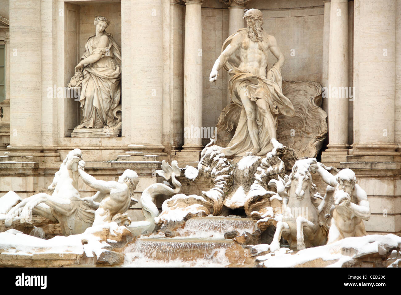 The statues of Trevi Fountain covered by snow, a really rare event in Rome Stock Photo