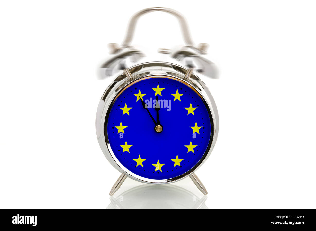 Ringing alarm clock with the European flag, time set to five minutes to