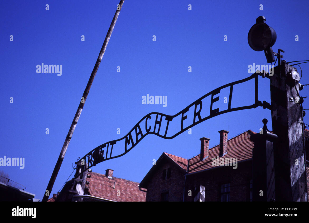 'Arbeit macht frei' sign in German language over the main gate entrance to Auschwitz concentration and extermination camp built and operated by the Third Reich in Polish areas annexed by Nazi Germany during World War II Stock Photo