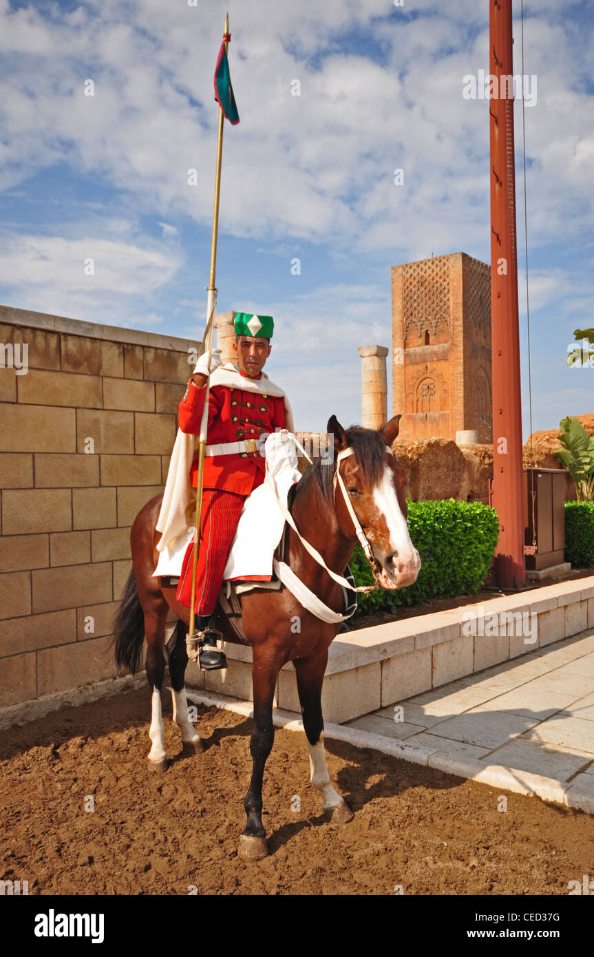 NORTH AFRICA, MOROCCO, Rabat, Mausoleum of King Mohammed V, guard in uniform on horseback with Hassan Mosque (1195) at rear Stock Photo