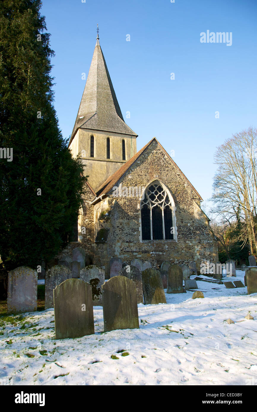 St James Church, Shere, Surrey on the banks of the River Tillingbourne on a snowy, sunny cloudless February day Stock Photo