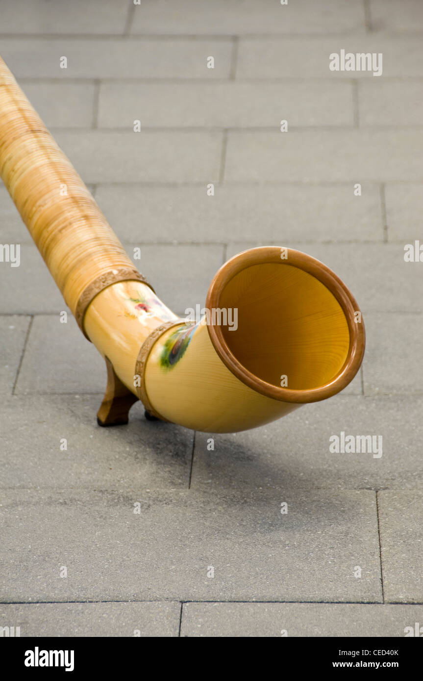 Vertical close up of the curved bell end of the traditional wooden Swiss instrument the Alpine Horn. Stock Photo