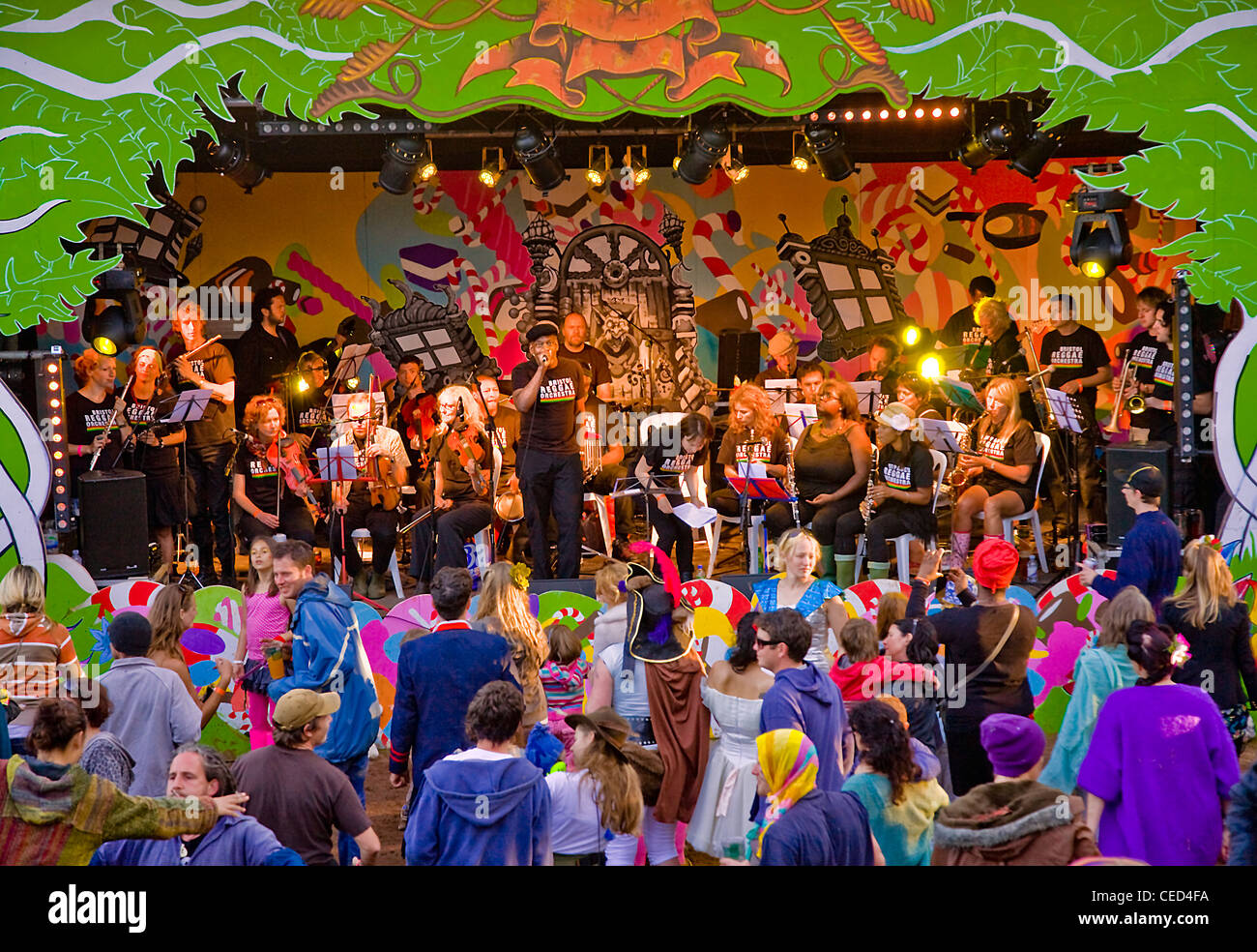orchestra pllaying on colourful festival stage with audience dancing Stock Photo