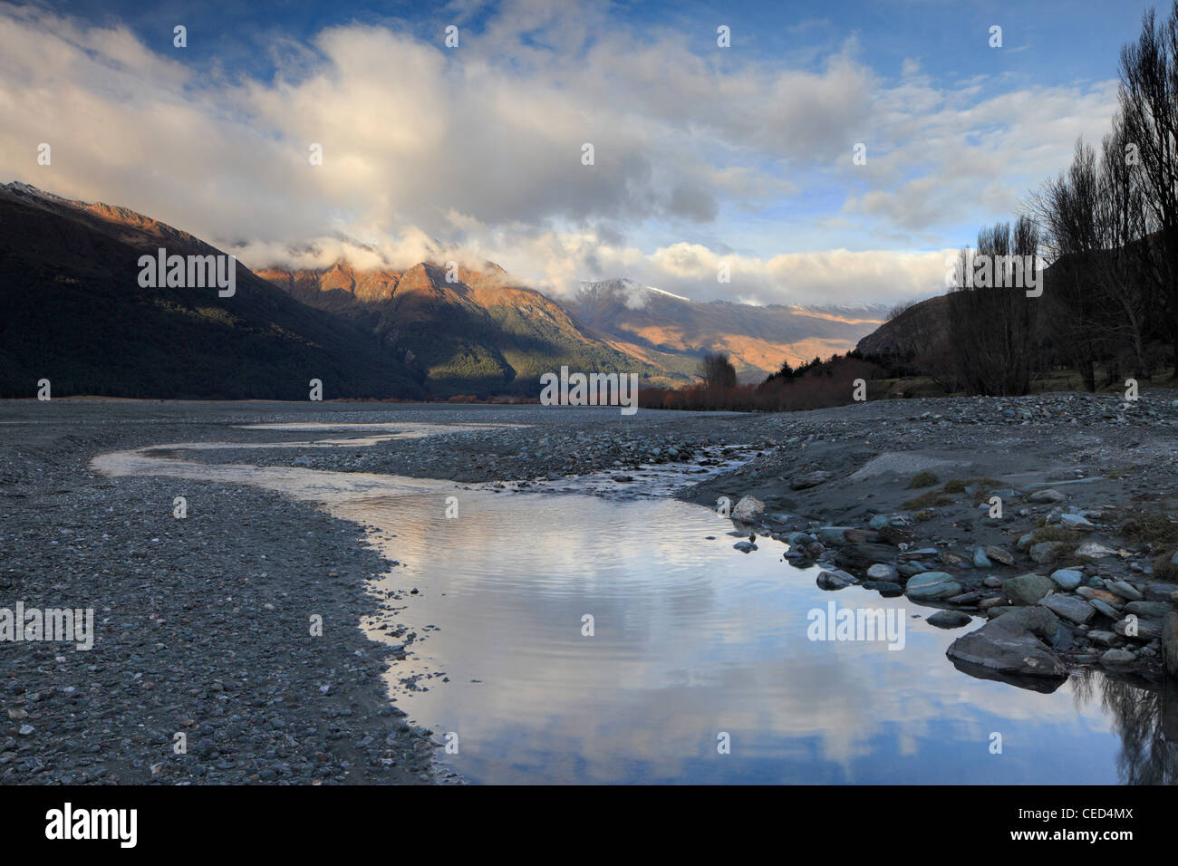 Snow-covered mountains reflected in an eddy of the Matukituki River in Mt Aspiring National Park Stock Photo