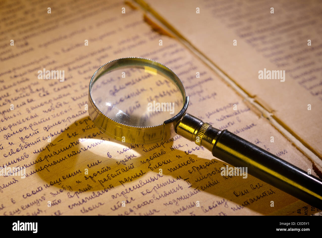 Magnifier glass on page of ancient manuscript, old newspaper Stock Photo
