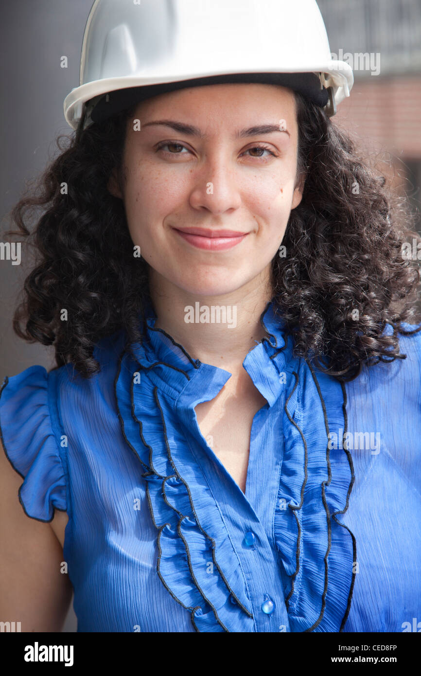 Smiling Hispanic businesswoman wearing hardhat Stock Photo Alamy