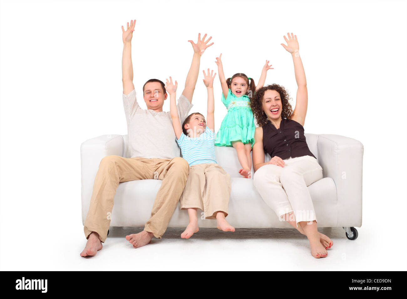Parents and children with rised hands  on white leather sofa Stock Photo