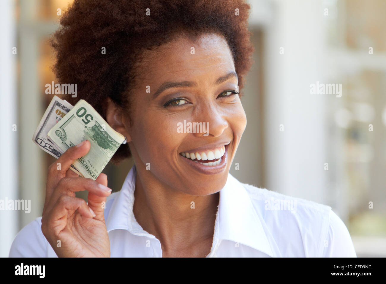 African American woman holding 50 dollar bill Stock Photo